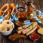 Traditional Bavarian food including sausages, pretzels and accompaniments served with Oktoberfest-style drinks